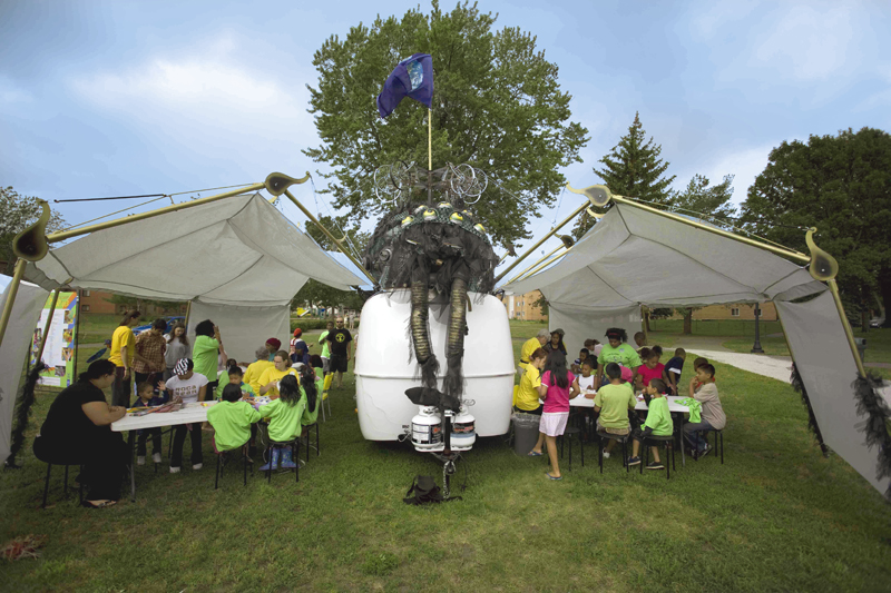 A large sculpture of a whimsical looking spider stretches its legs over a Public Art St. Paul event.